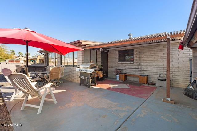 view of patio / terrace with outdoor dining area, a grill, and fence