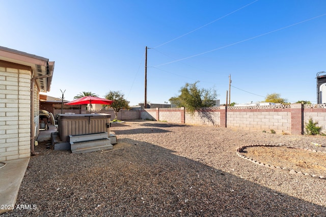 view of yard featuring a fenced backyard and a hot tub