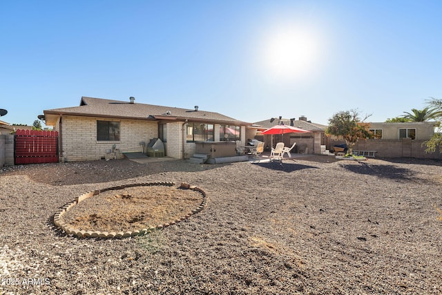 rear view of property featuring brick siding, a patio area, and a fenced backyard