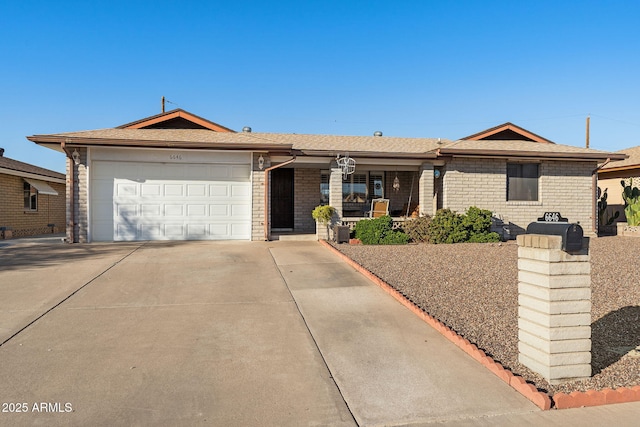 ranch-style home featuring driveway, brick siding, and an attached garage