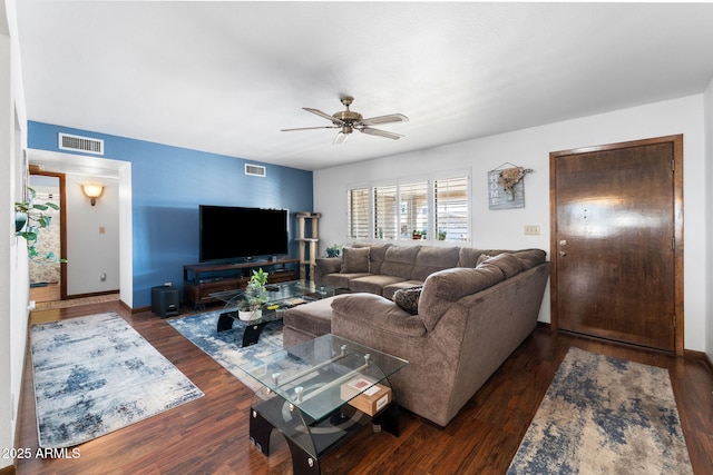 living area featuring a ceiling fan, visible vents, and wood finished floors