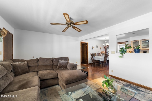 living area featuring wood finished floors and ceiling fan with notable chandelier