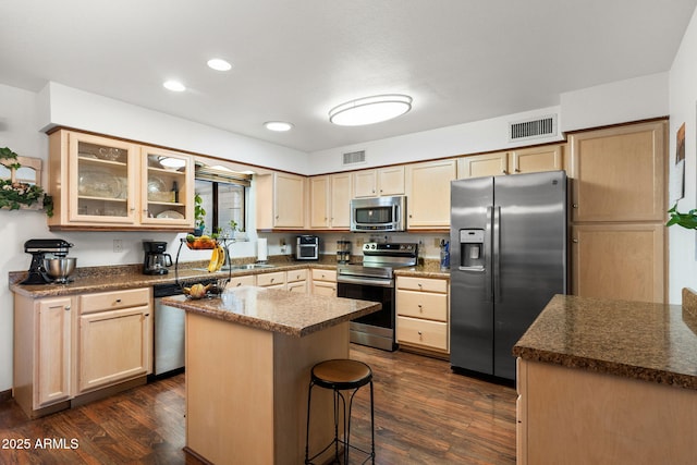 kitchen featuring stainless steel appliances, dark wood-type flooring, glass insert cabinets, and visible vents