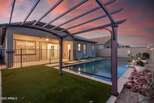 pool at dusk with a lawn, a patio, a pergola, and pool water feature