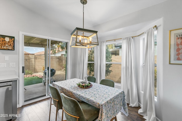 dining space with a chandelier, lofted ceiling, and hardwood / wood-style floors