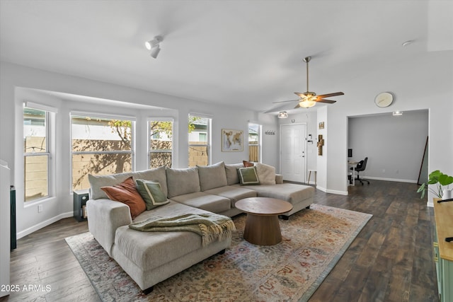 living area with baseboards, dark wood-style flooring, and ceiling fan