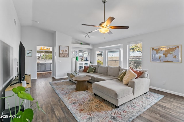 living room featuring baseboards, lofted ceiling, a ceiling fan, and dark wood-style flooring