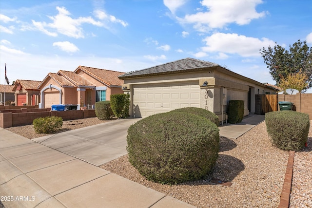 single story home with fence, a tile roof, concrete driveway, stucco siding, and an attached garage