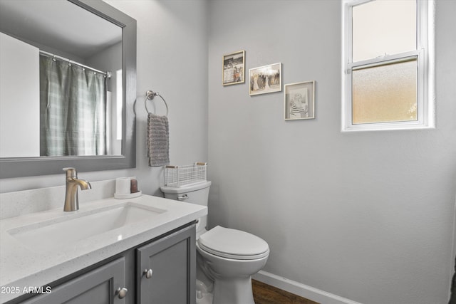 bathroom featuring a shower with curtain, baseboards, toilet, and vanity