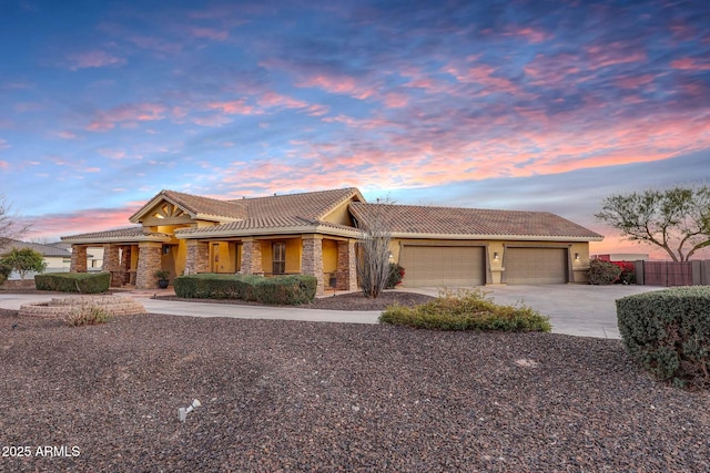 view of front of home with a garage, fence, stone siding, driveway, and stucco siding