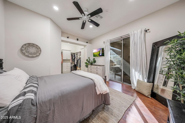 bedroom with visible vents, wood finished floors, access to exterior, a walk in closet, and recessed lighting