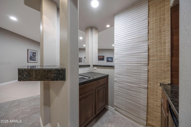 kitchen with light tile patterned floors, dark stone counters, and recessed lighting