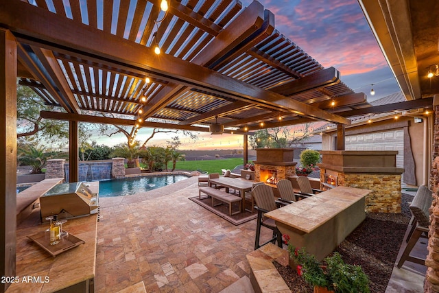 view of patio featuring an outdoor pool, an outdoor stone fireplace, a pergola, and exterior kitchen