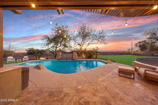 pool at dusk with a yard, a patio area, fence, and a fenced in pool