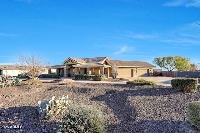 view of front of property featuring concrete driveway, fence, and an attached garage