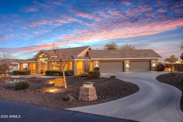view of front of house with a garage, fence, driveway, a tiled roof, and stucco siding