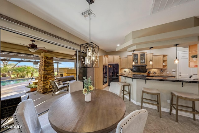 dining space featuring light tile patterned floors, visible vents, and a ceiling fan