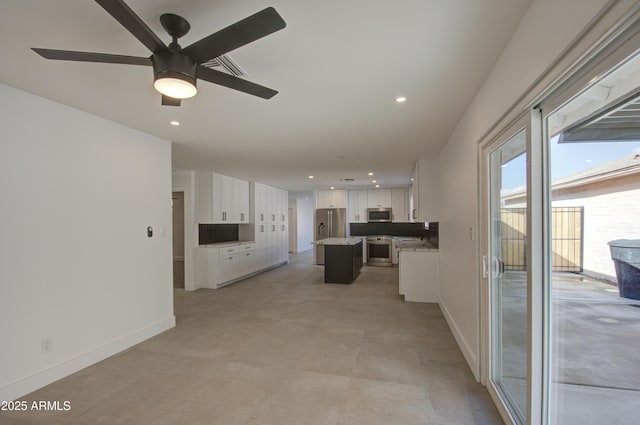 kitchen with white cabinetry, ceiling fan, stainless steel appliances, and a center island