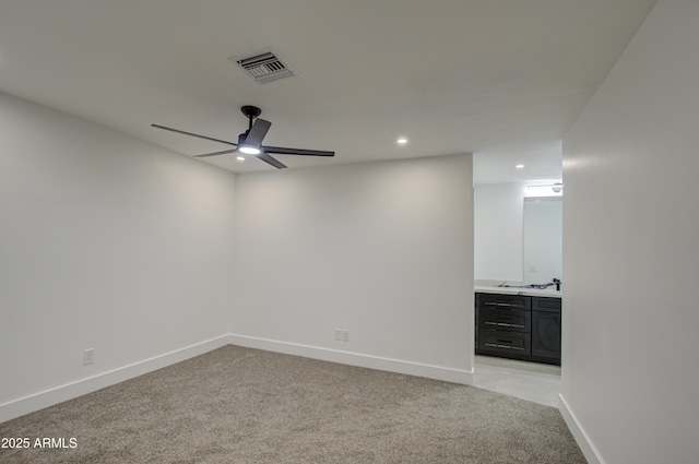 carpeted spare room featuring ceiling fan