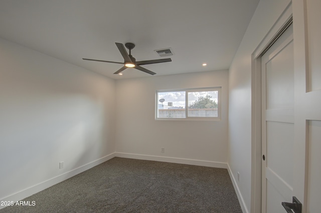 empty room featuring ceiling fan and dark colored carpet