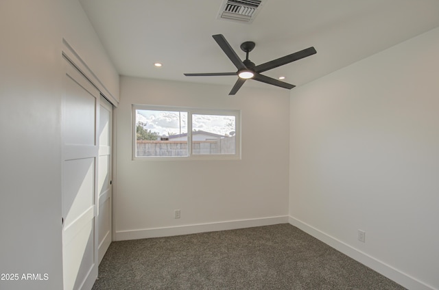 unfurnished bedroom featuring dark colored carpet, ceiling fan, and a closet