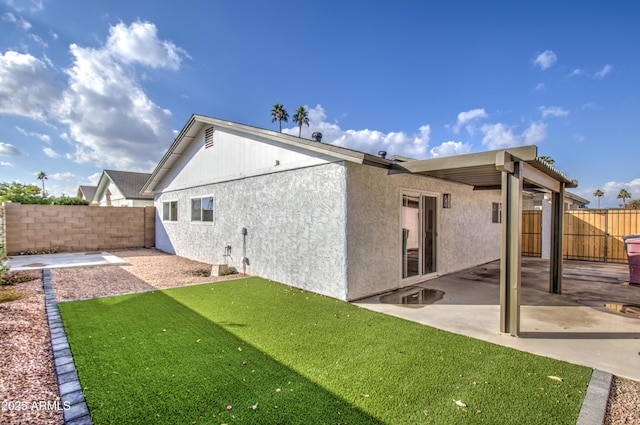 back of house featuring a yard and a patio