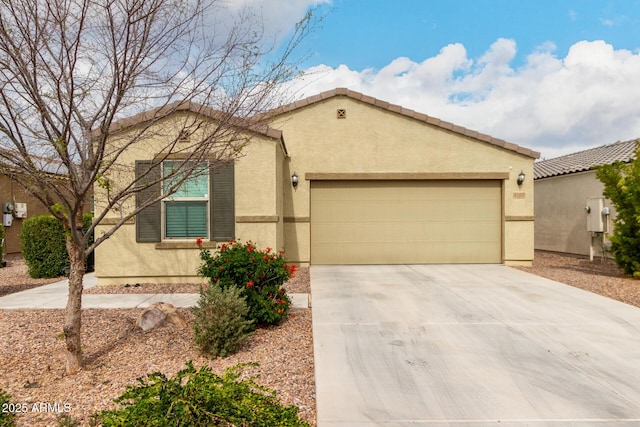 view of front of house featuring a garage, driveway, a tile roof, and stucco siding