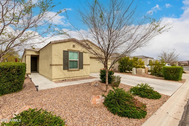 view of front of house with a garage, driveway, a tiled roof, and stucco siding