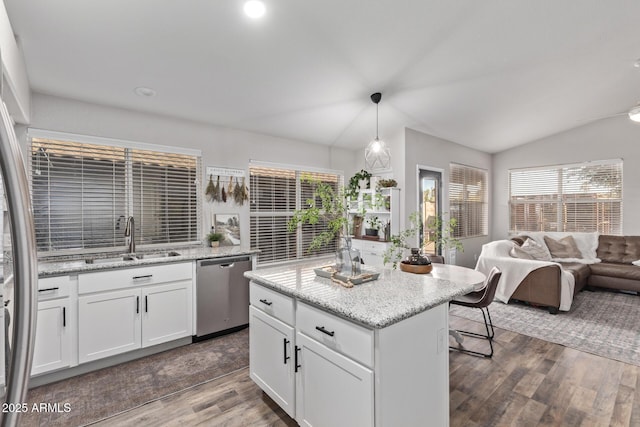 kitchen featuring appliances with stainless steel finishes, sink, white cabinets, hanging light fixtures, and a center island