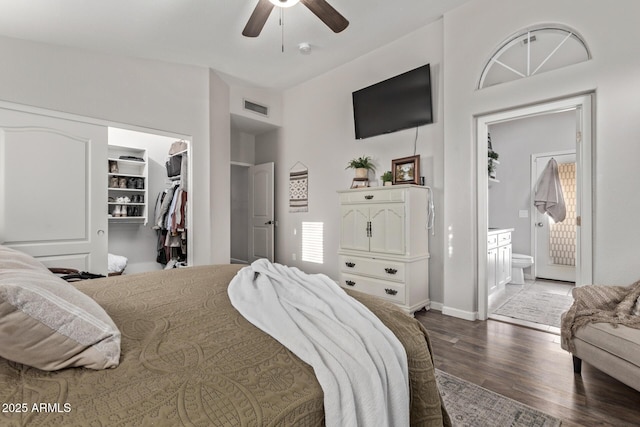 bedroom featuring hardwood / wood-style floors, connected bathroom, a walk in closet, ceiling fan, and a closet