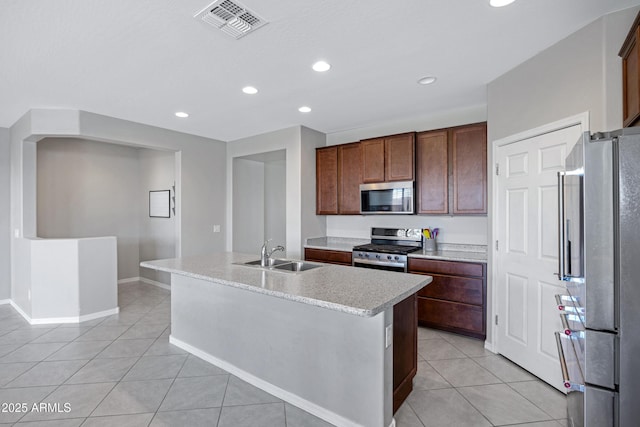 25974 W Horsham Dr, Buckeye, AZ 85396 - kitchen with stainless steel appliances, light tile patterned floors, recessed lighting, light countertops, and a center island with sink