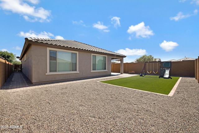 25974 W Horsham Dr, Buckeye, AZ 85396 - back of house with a playground, a tiled roof, a fenced backyard, and stucco siding