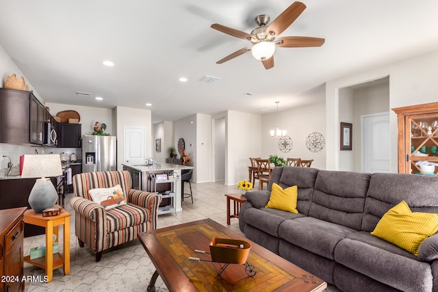 living room with sink and ceiling fan with notable chandelier