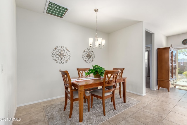 dining space featuring light tile patterned floors and a chandelier