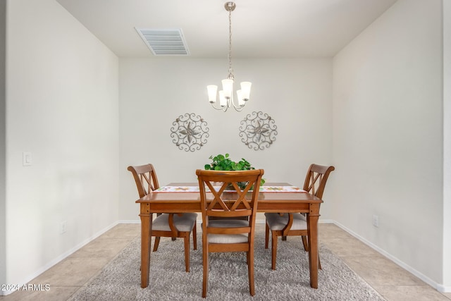 tiled dining room featuring a chandelier