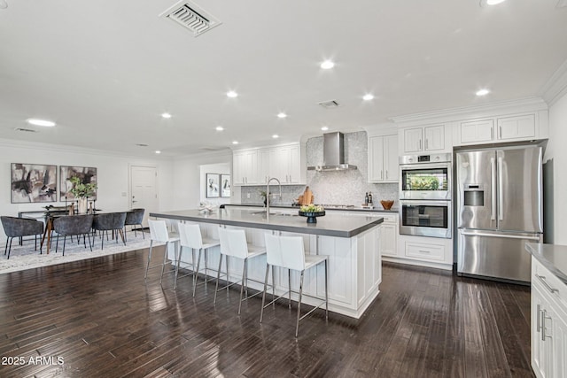 615 E Winter Dr, Phoenix, AZ 85020 - kitchen featuring stainless steel appliances, wall chimney range hood, ornamental molding, a kitchen breakfast bar, and white cabinetry