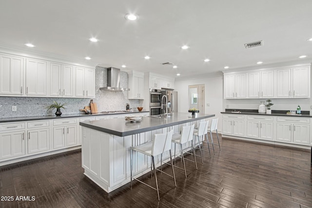 615 E Winter Dr, Phoenix, AZ 85020 - kitchen with wall chimney range hood, dark countertops, crown molding, stainless steel appliances, and backsplash