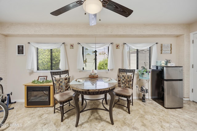 dining room with ceiling fan and baseboards
