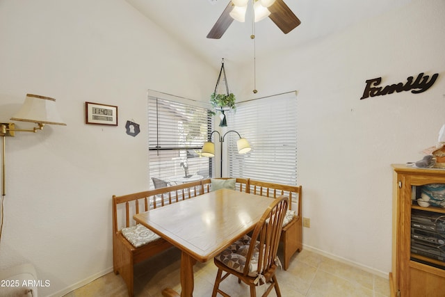 dining room with a ceiling fan, lofted ceiling, and baseboards