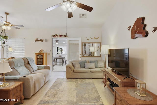 living area with a ceiling fan and light tile patterned floors
