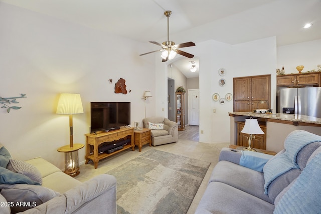 living area featuring lofted ceiling, ceiling fan, and light tile patterned floors