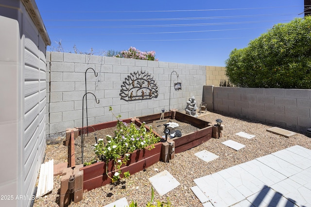 fenced backyard featuring a garden