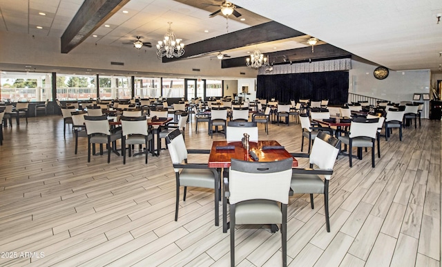 dining space featuring ceiling fan, a chandelier, wood finished floors, and beamed ceiling