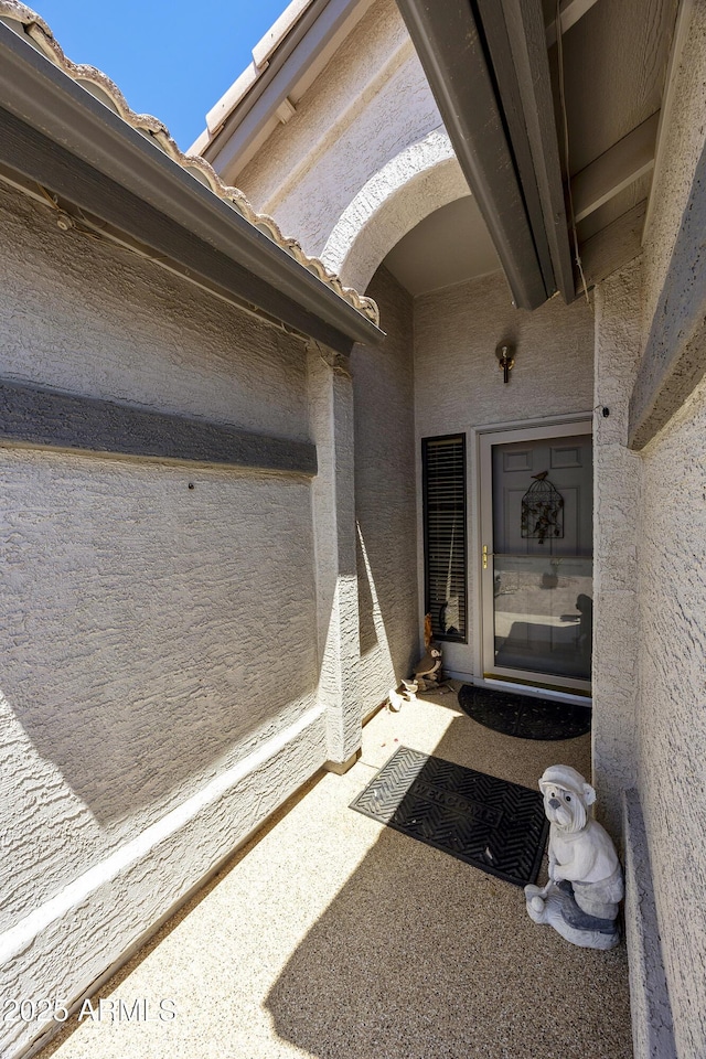 doorway to property featuring stucco siding