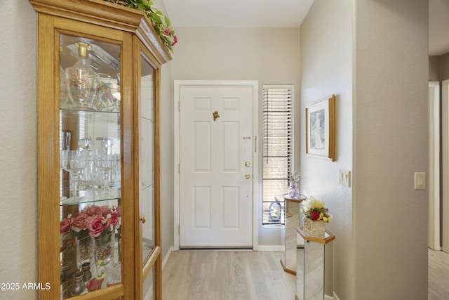 entryway featuring light wood finished floors and baseboards