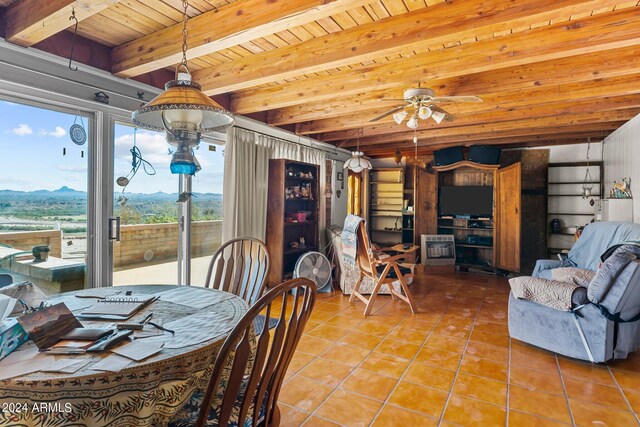 dining area with wooden ceiling, beam ceiling, ceiling fan, and a mountain view