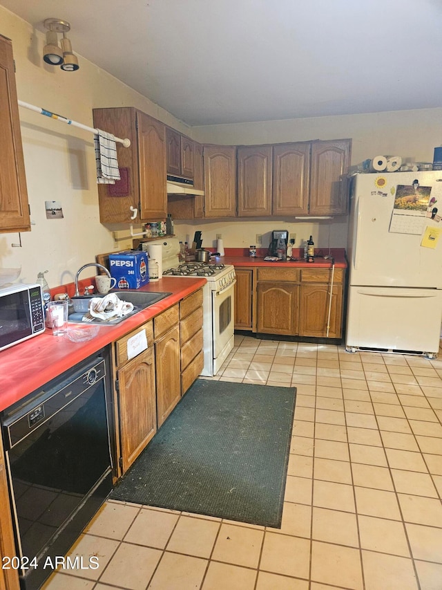 kitchen with white appliances, sink, and light tile patterned flooring