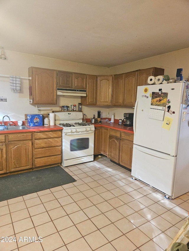 kitchen with light tile patterned floors, white appliances, and sink