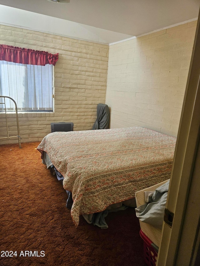 bedroom with carpet flooring and brick wall