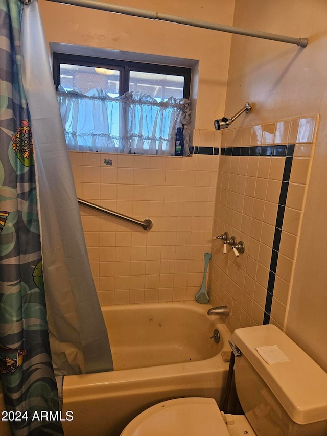 bathroom featuring toilet and shower / tub combo with curtain